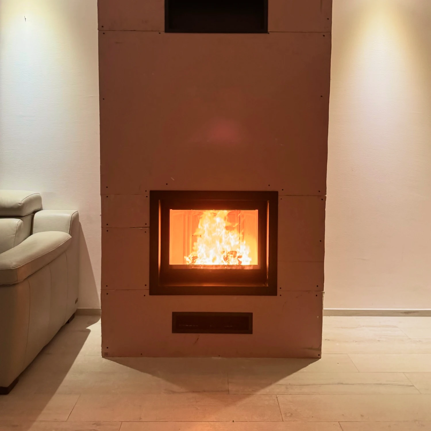 Cheminée encastrée allumée avec un feu vif dans un salon moderne clair.
