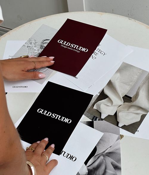 Hands laying images of Guld Studio on a table