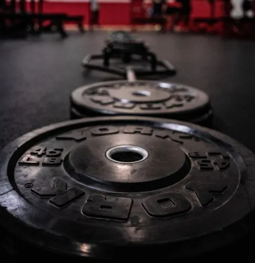there are two black plates on the floor in a gym