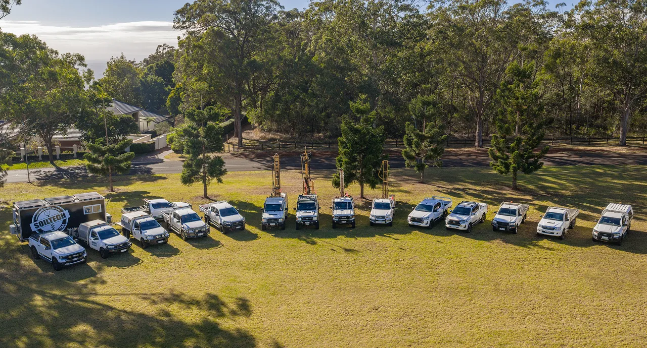 Row of crew vehicles at Soiltech Testing Services site setup in rural field