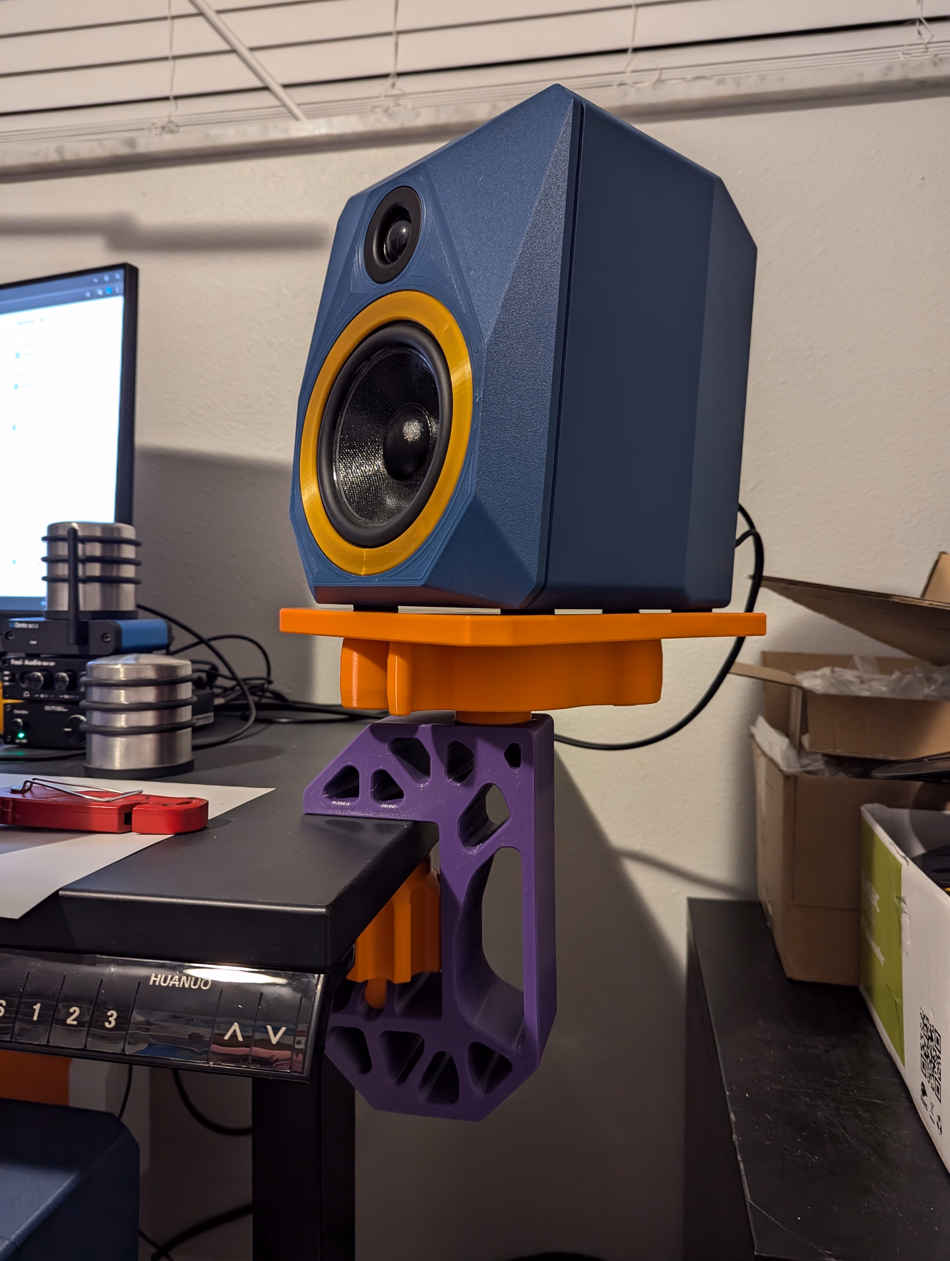 Blue PETG-CF with gold PETG accent FDMGeo on a desk speaker stand