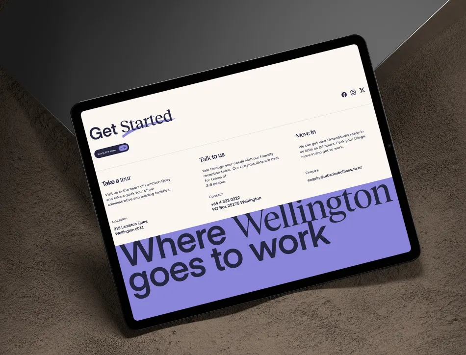 Tablet on dark surface displaying a website with "Get started" heading and large purple text reading "Where Wellington goes to work