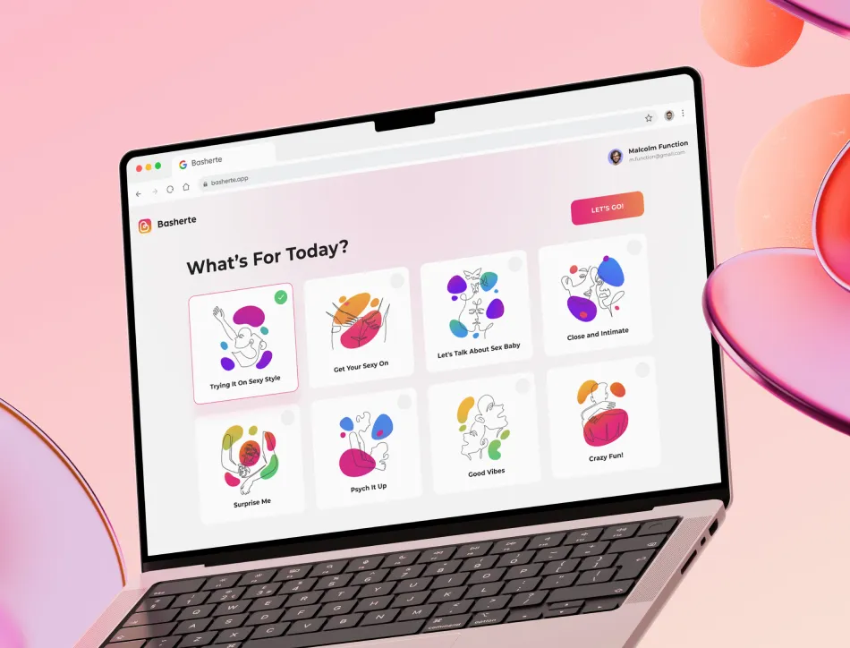 Laptop with keyboard on pink fabric displaying a colorful illustrated interface titled "What's the mood?" with cartoon emotion icons and character illustrations