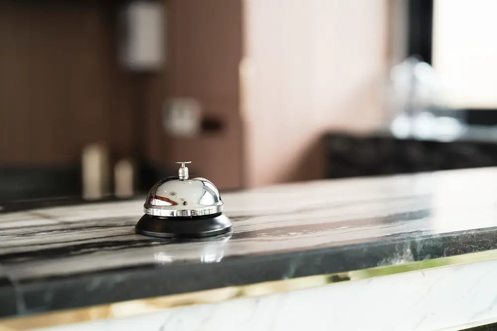 A shiny service bell on a marble countertop, symbolizing guest service at Courtyard Asheville Biltmore Village.