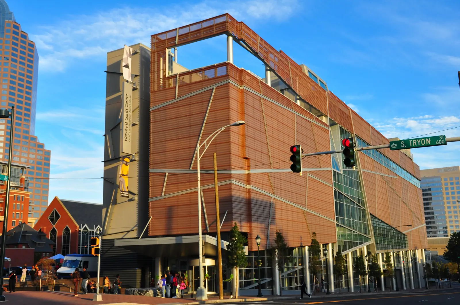 Exterior view of the Harvey B. Gantt Center, featuring its modern multilayered facade under blue sky at the intersection of S. Tryon St.