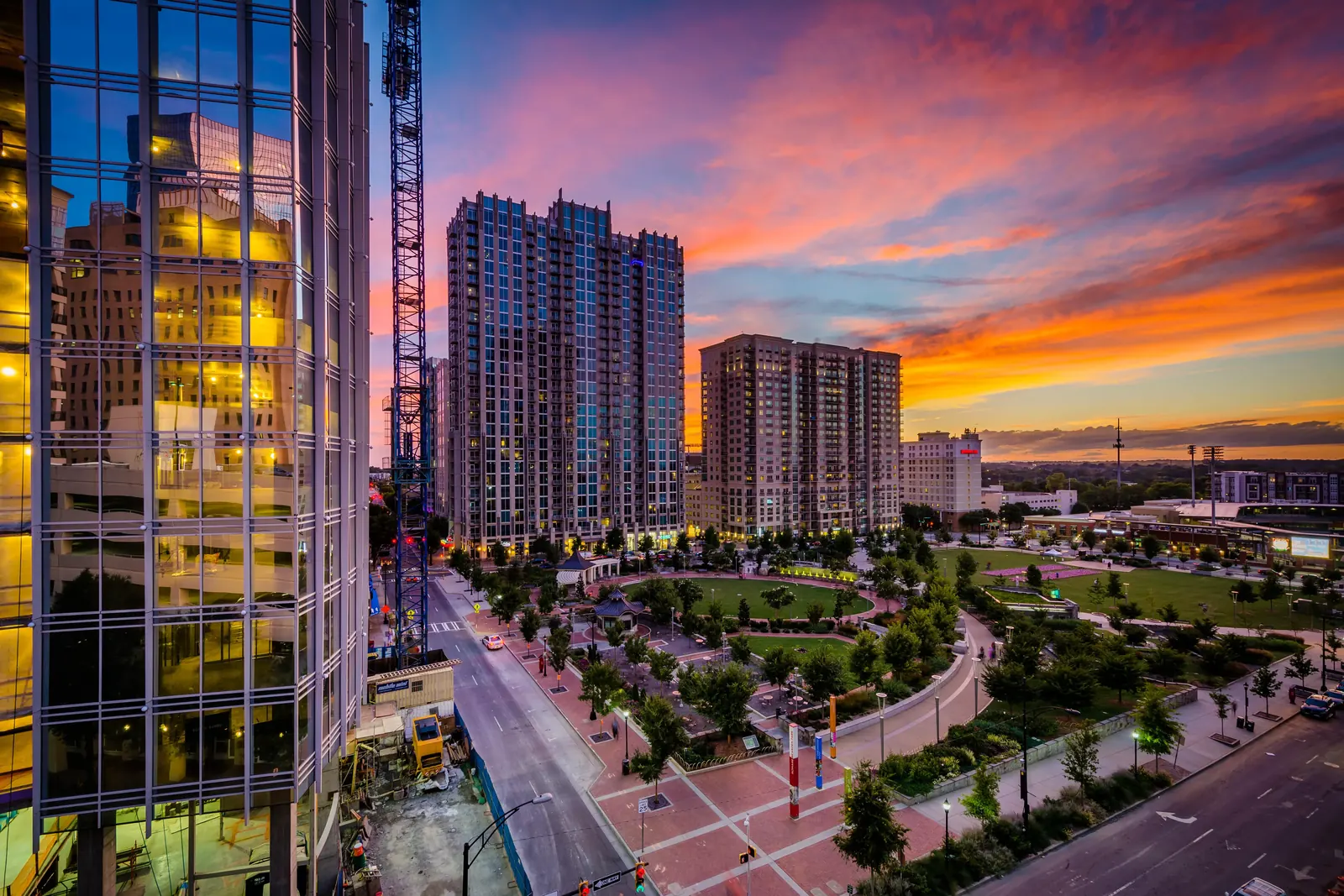 Sunset over Romare Bearden Park showcasing glowing skyline and lush greenery.
