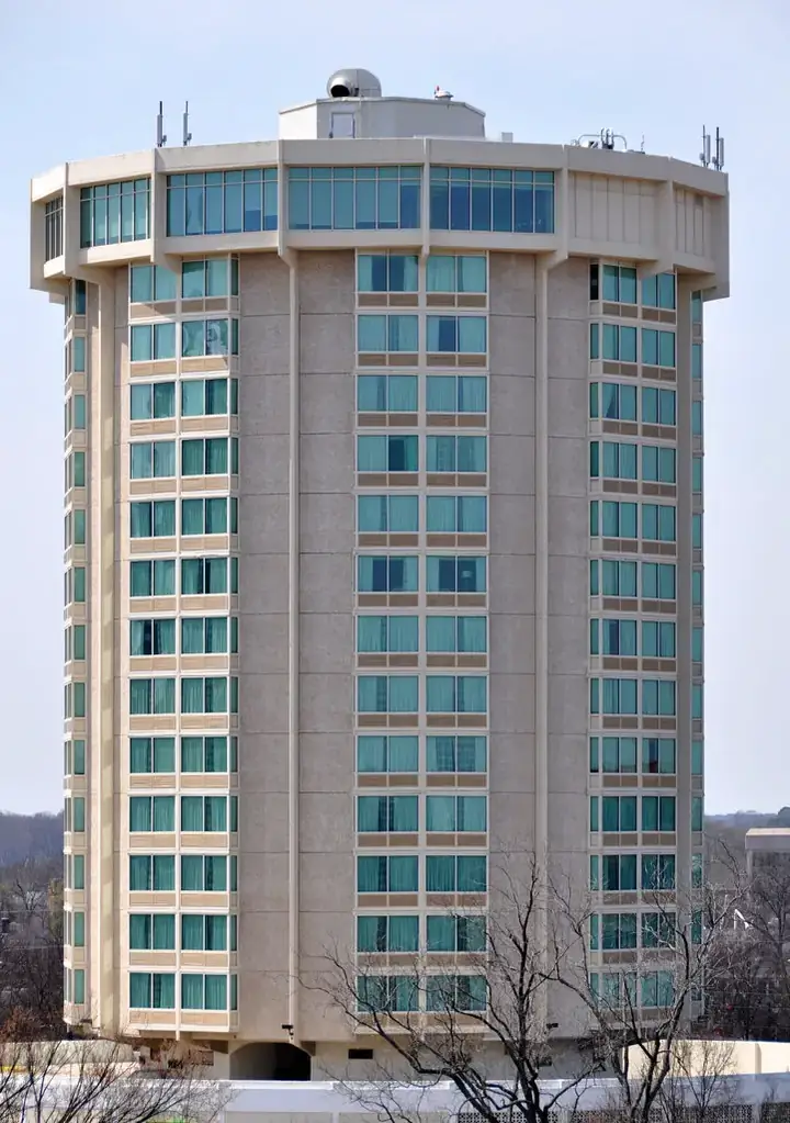 Tall cylindrical building with blue-tinted windows, representing the Holiday Inn Raleigh Downtown.