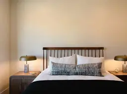 Elegant room at Hampton Inn & Suites Raleigh-Durham with cozy queen bed, stylish lamps, and minimalist decor.