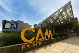 CAM Raleigh museum exterior with yellow lettering in front and modern architecture, set against street art murals.