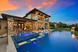 Luxurious Sanderling Resort villa at dusk with illuminated infinity pool and fire feature, reflecting the vibrant sunset sky.