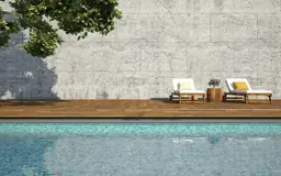 Tranquil poolside scene with two lounge chairs and a decorative table at Compass Cove Oceanfront Resort.