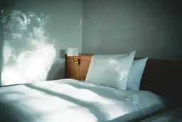 Comfortable hotel room with plush white bedding and natural light at Hyatt House Raleigh/RDU/Brier Creek.