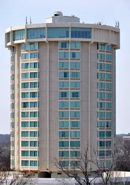 Tall cylindrical building with blue-tinted windows, representing the Holiday Inn Raleigh Downtown.