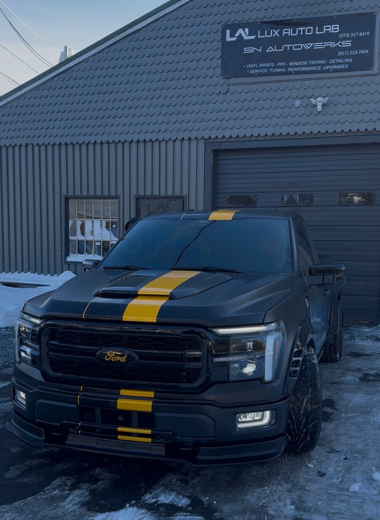 Ford F-150 with matte black and yellow racing stripe vinyl wrap by Lux Auto Lab