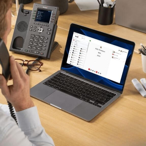 Employee handling a business call using an IP desk phone