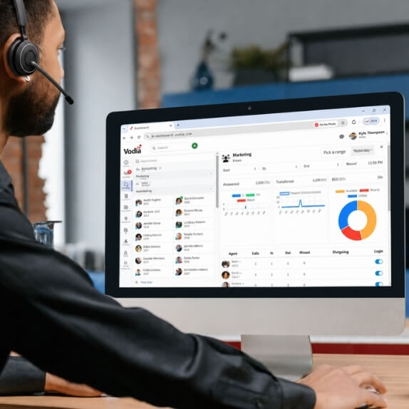 Employee wearing a headset while using the Vodia desktop interface