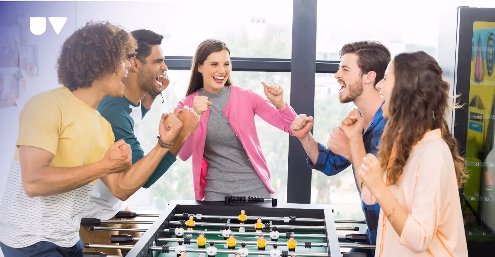 Employees playing foosball in an office.