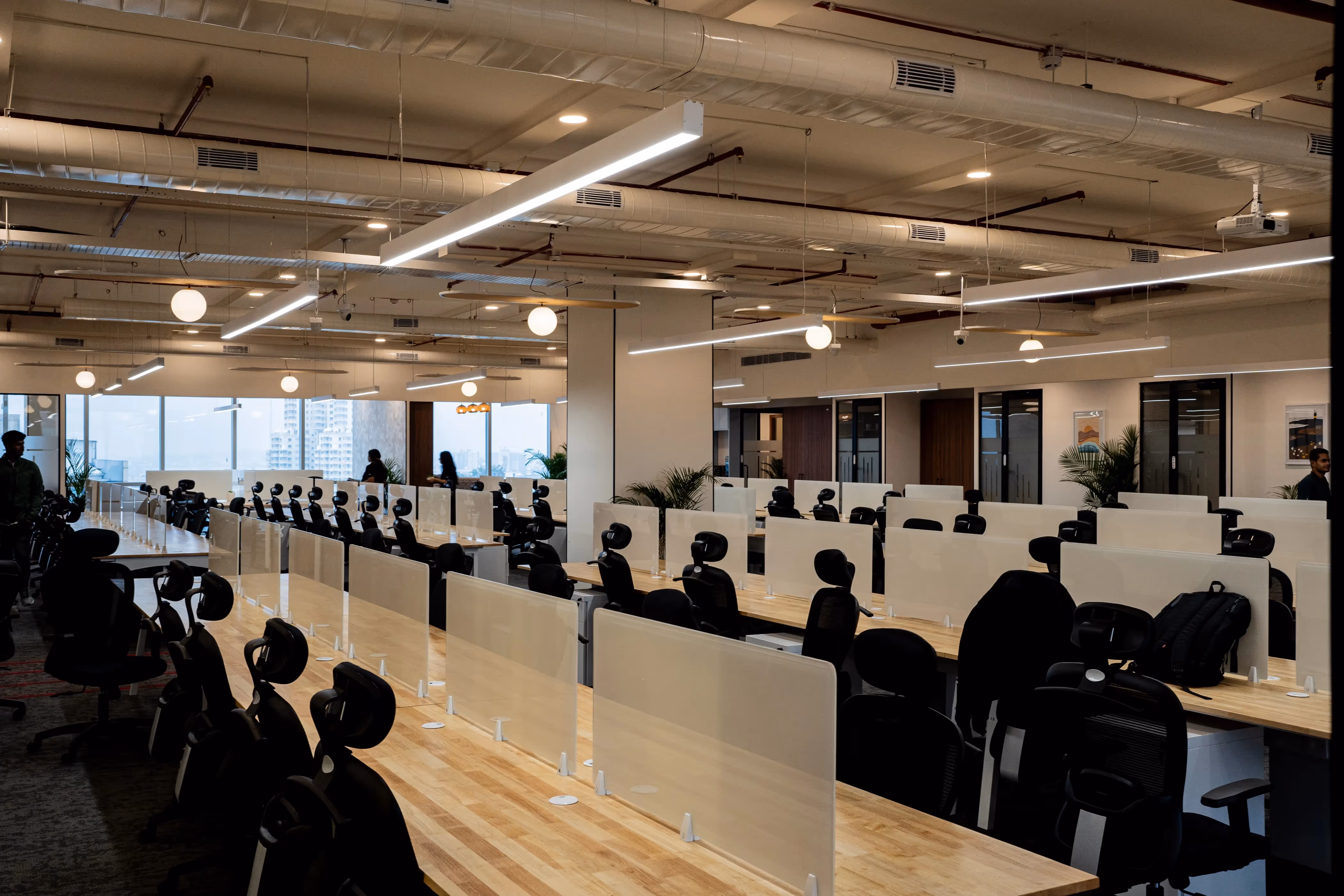 Office space in Baner with people seated on chairs, tables, and standard office flooring