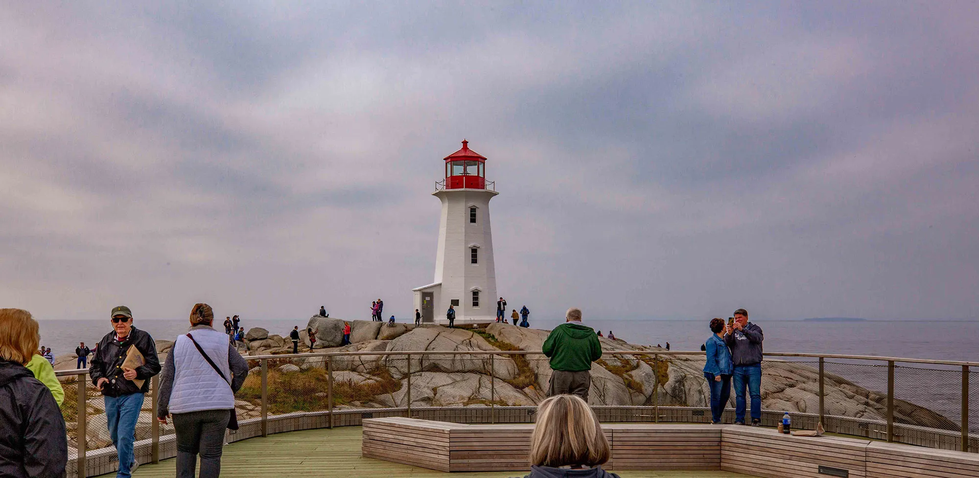 Visitors view and photograph Peggy's Cove lighthouse from the recently built viewing platform.