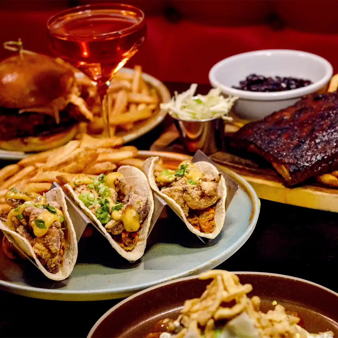 A plate of tacos, steak and a burger and fries.