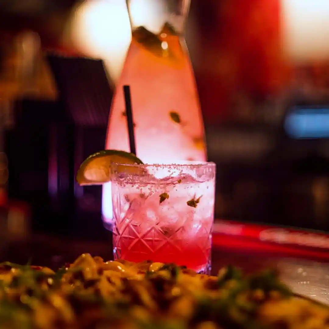 A colourful cocktail back lit with light.