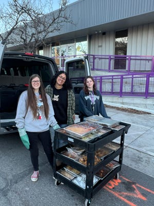 Food trays from the Toucan Charlie's buffet at the Atlantis Casino Resort Spa are transported to the Eddy House by members of its youth advocates team.