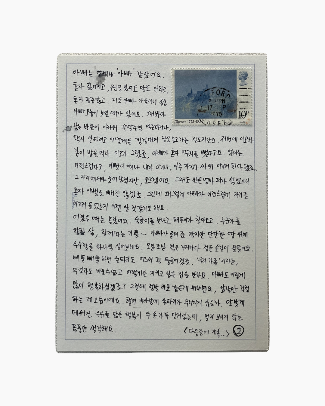 손글씨로 쓴 한국어 편지가 직사각형의 종이에 적혀 있으며, 오른쪽 위에는 파란색 풍경 그림이 있는 영국 우표가 붙어 있다.