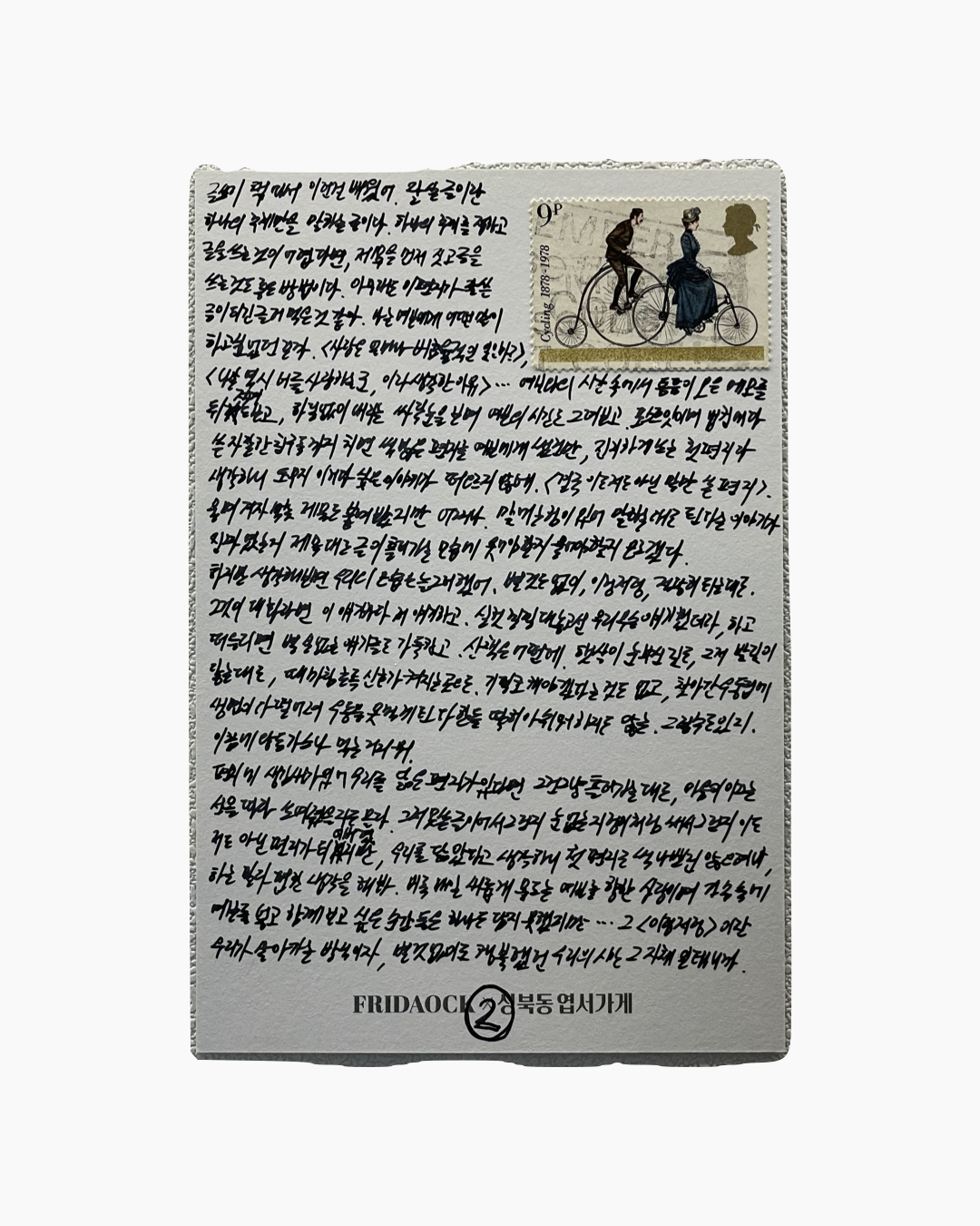 손으로 쓴 한글 글씨가 빽빽하게 적힌 종이와 오른쪽 상단에 올드스타일 자전거를 타는 남녀가 그려진 영국 우표가 붙어 있음.