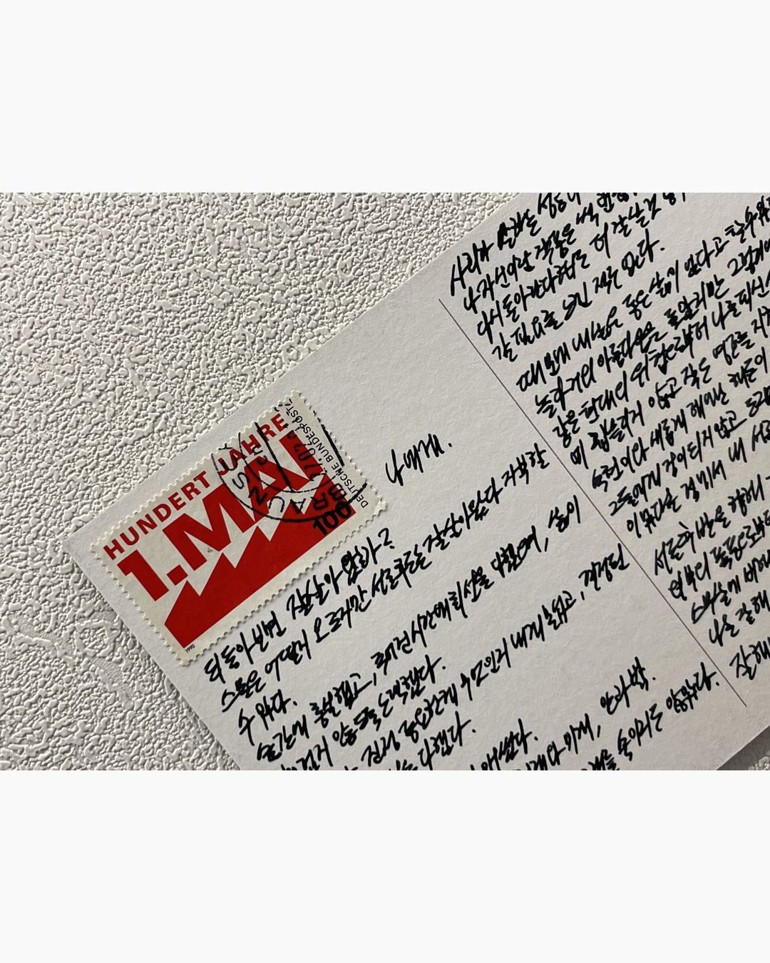 수제 우표가 부착된 흰색 봉투에 한글로 손으로 쓴 편지 내용이 적혀 있음.