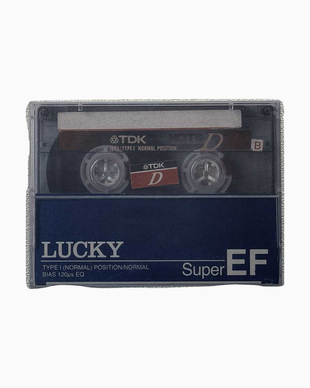 투명 케이스에 담긴 TDK 타입 I 노멀 포지션 오디오 카세트 테이프, 하단에 'LUCKY Super EF' 문구.