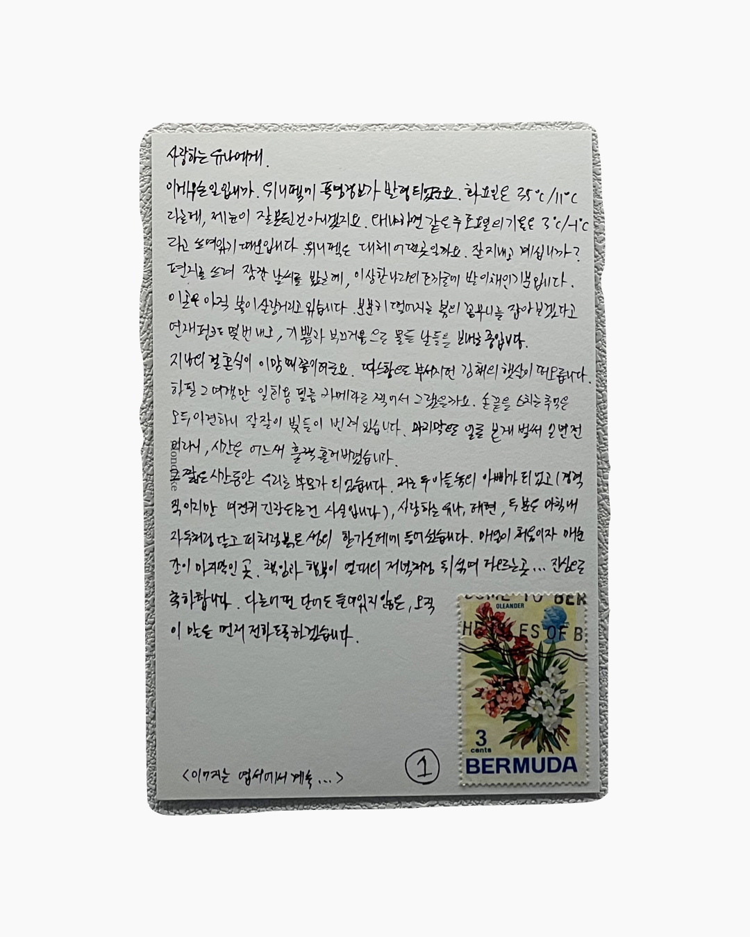 손글씨로 쓴 한국어 편지와 베르뮤다 올레안더 꽃 무늬 우표가 붙어 있는 엽서.