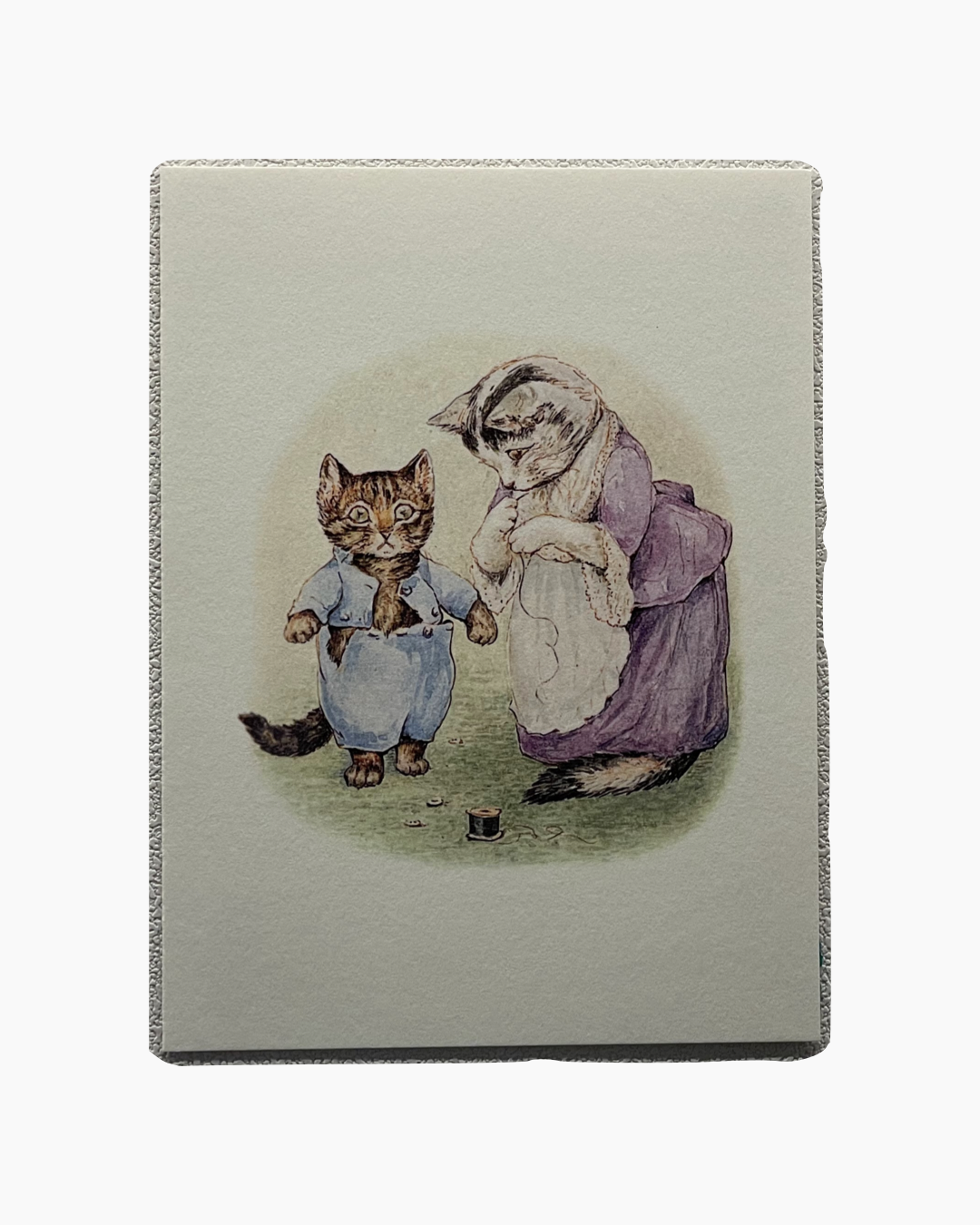 엄마 고양이가 보라색 드레스와 앞치마를 입고 아기 고양이의 옷을 꿰매고 있다.