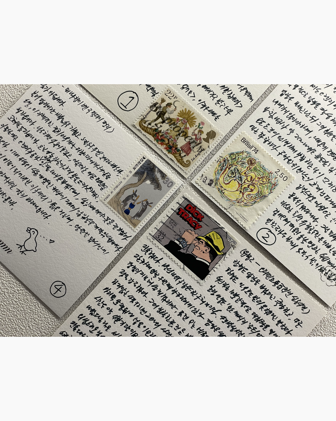 네 장의 손글씨 편지 위에 각각 다양한 그림이 그려진 우표가 붙어 있다.