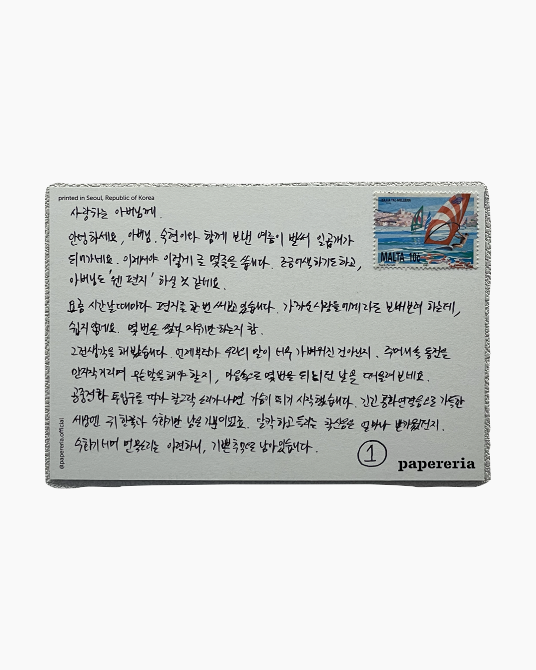 한국어로 손글씨가 적힌 엽서 앞면과 말타 우표가 보임.