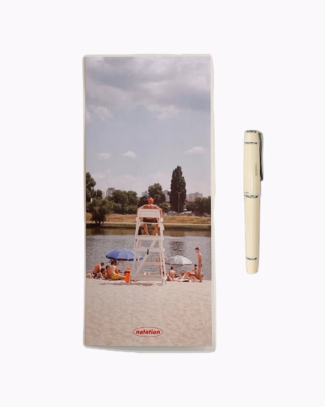 해변 모래사장에 수영장 구명요원 의자에 앉아 있는 사람과 주변에 있는 사람들이 강가에서 휴식하는 모습.