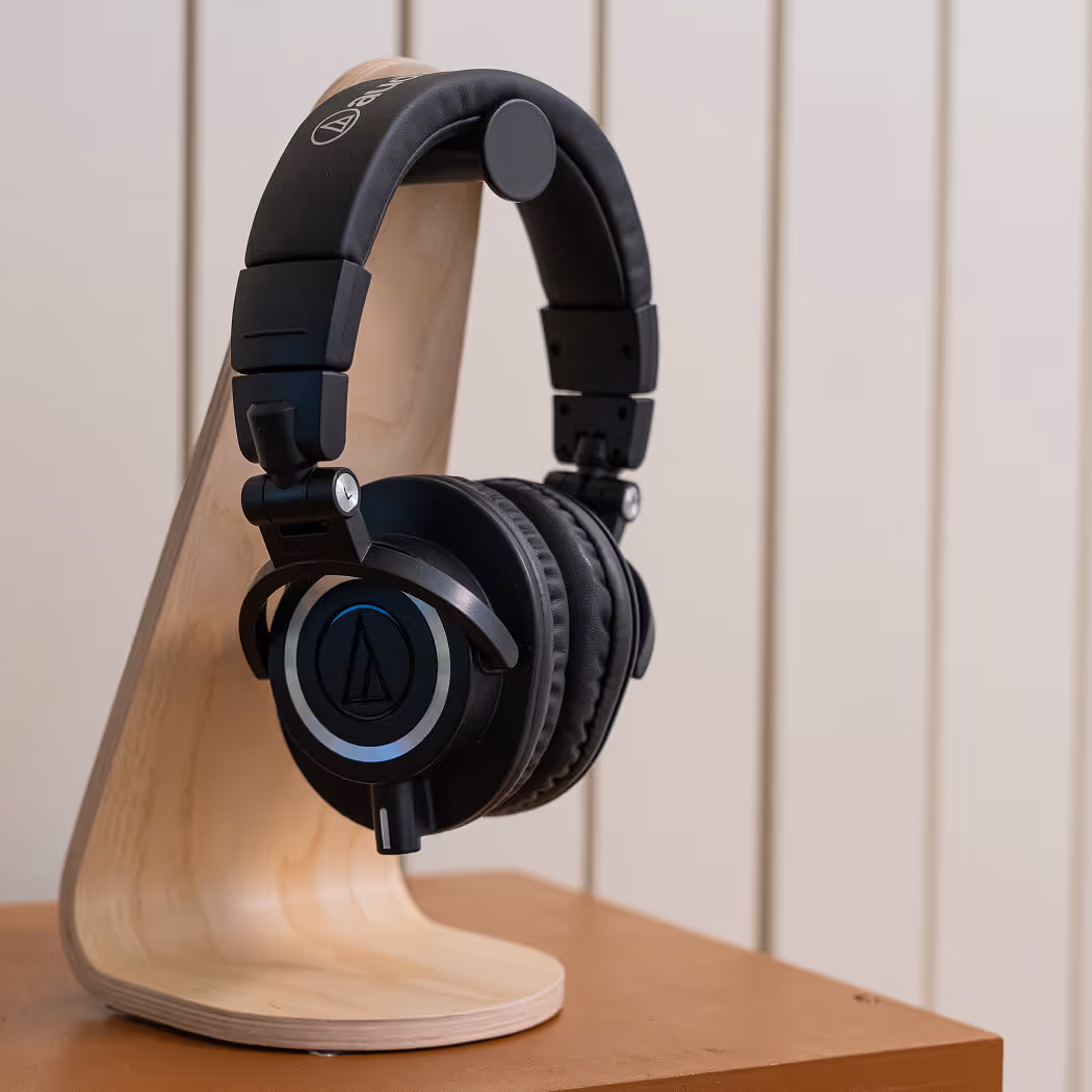 אוזניות Audio-Technica ATH-M50x על מעמד עץ