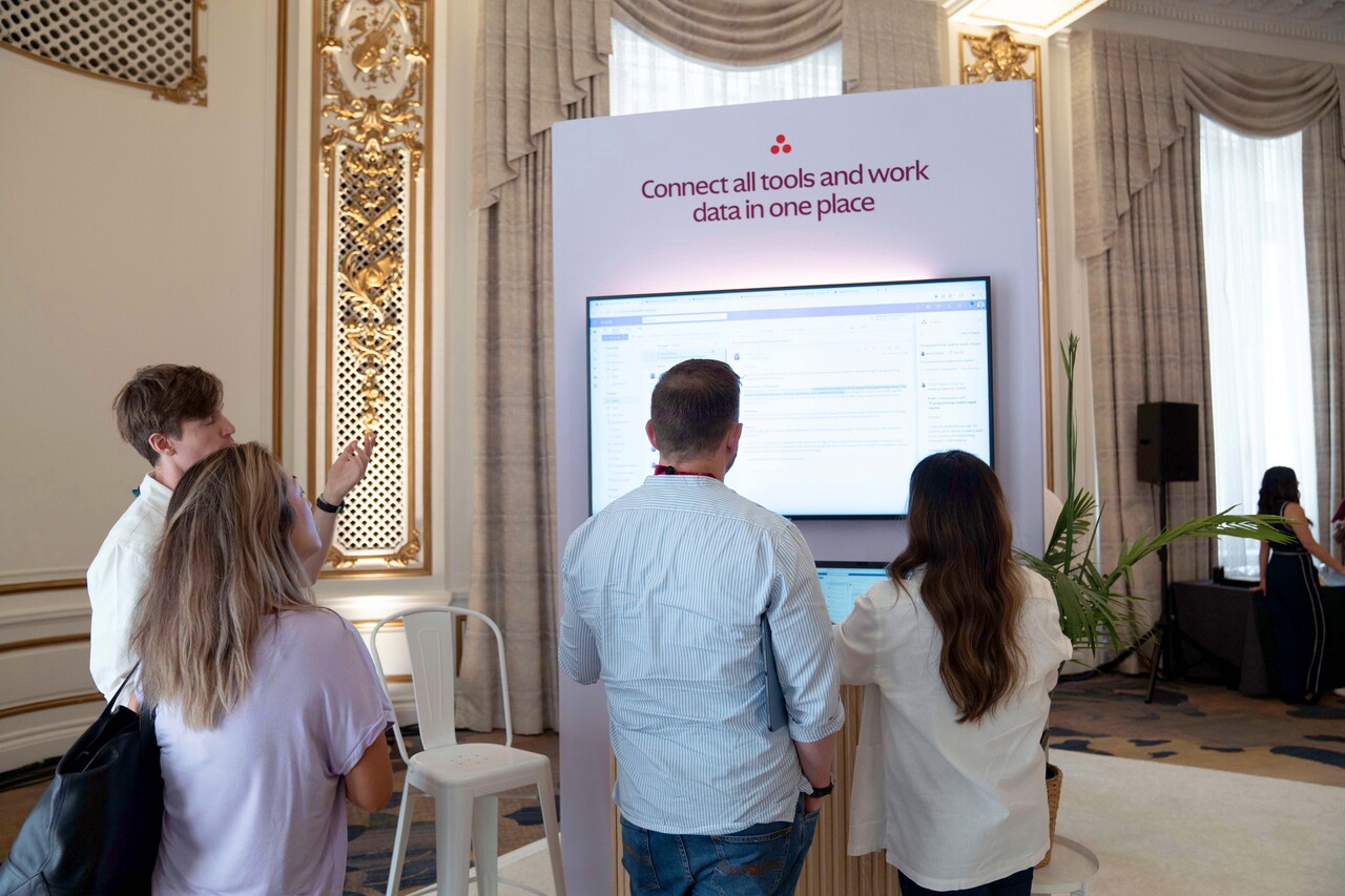 people gathering around the Asana screen to see the operations in Asana