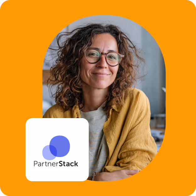 Smiling woman with curly hair and glasses wearing a yellow shirt with PartnerStack logo.
