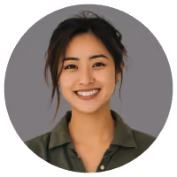 Smiling young woman with dark hair wearing green shirt against gray background.