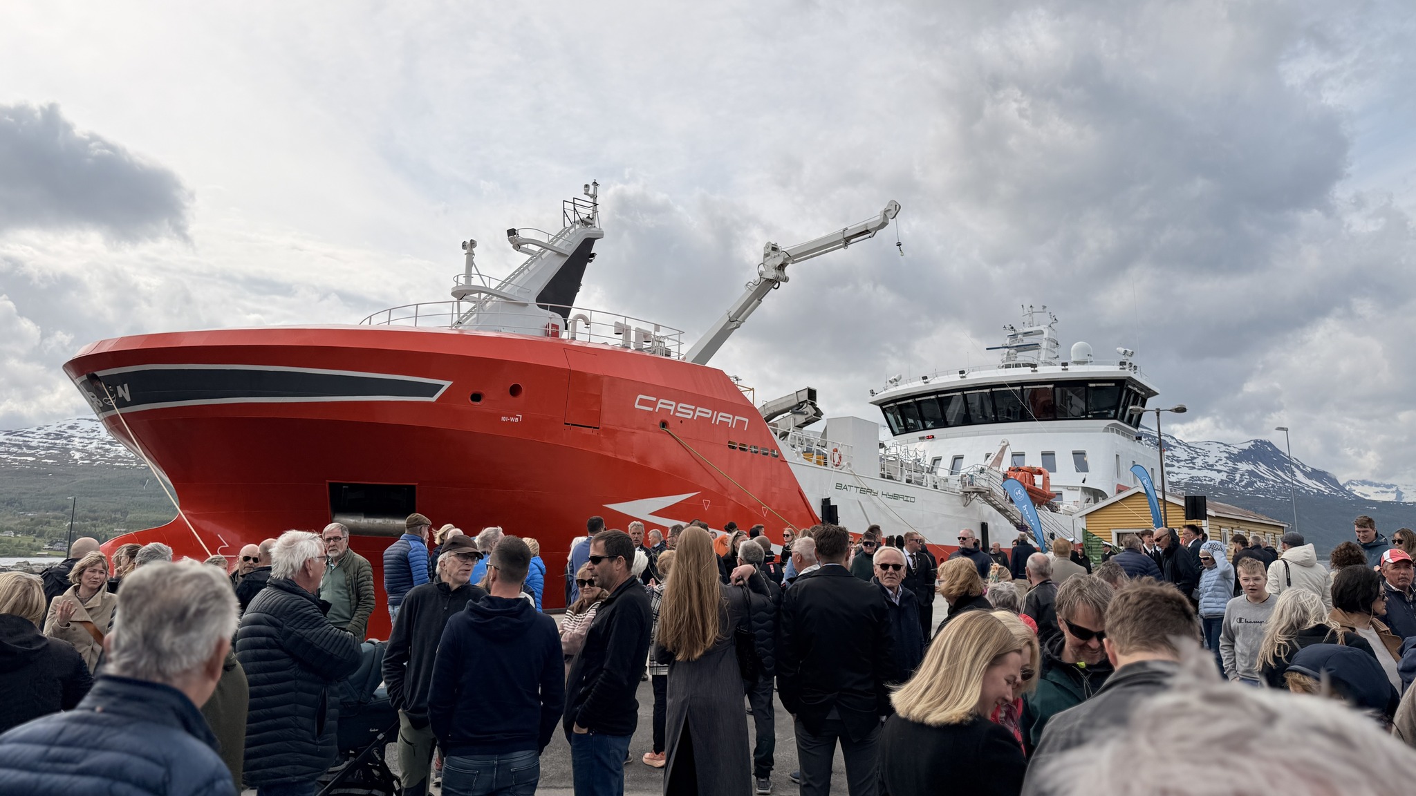 En brygge full av mennesker, med båten Caspian i bakgrunnen
