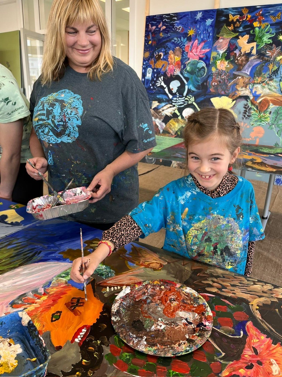 A lady with blonde hair and a young girl painting a picture for the Alloway Tunnel.