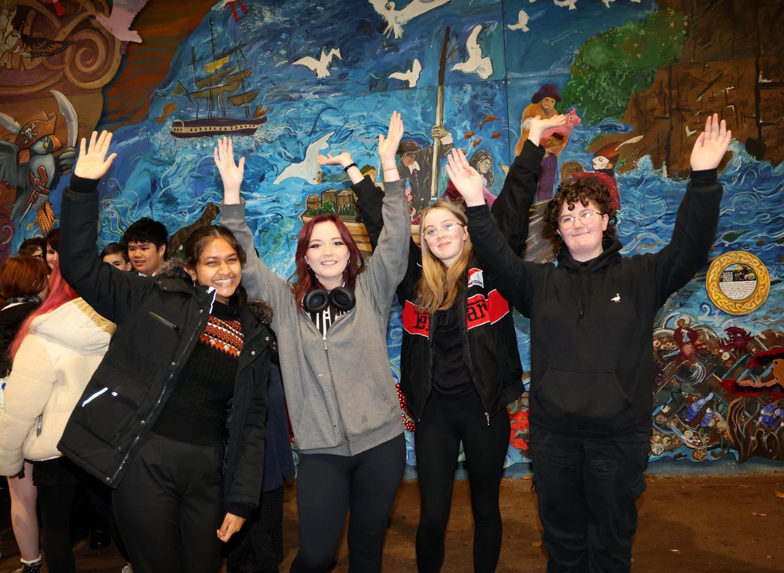 a group of young people standing together holding their hands up in the Alloway Tunnel.