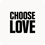 Man with beard in a blue suit and white shirt sitting at a table with clasped hands.