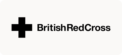 Man with beard in a blue suit and white shirt sitting at a table with clasped hands.