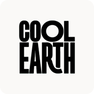 Man with beard in a blue suit and white shirt sitting at a table with clasped hands.