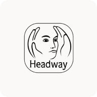 Man with beard in a blue suit and white shirt sitting at a table with clasped hands.