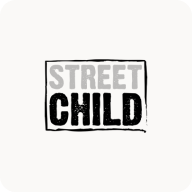 Man with beard in a blue suit and white shirt sitting at a table with clasped hands.