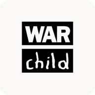 Man with beard in a blue suit and white shirt sitting at a table with clasped hands.