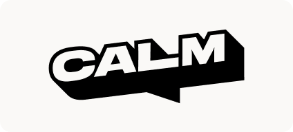 Man with beard in a blue suit and white shirt sitting at a table with clasped hands.