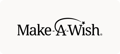 Man with beard in a blue suit and white shirt sitting at a table with clasped hands.